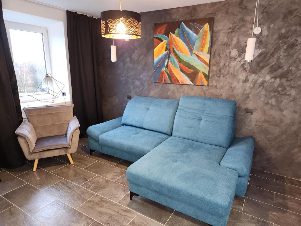 sala de estar con sofá azul y silla en LaWa, en Sillamäe
