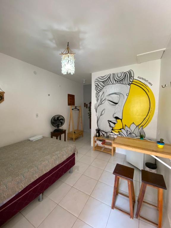 Zimmer mit einem Bett und einem Wandgemälde in der Unterkunft Lotus Flat - Canoa Quebrada in Aracati