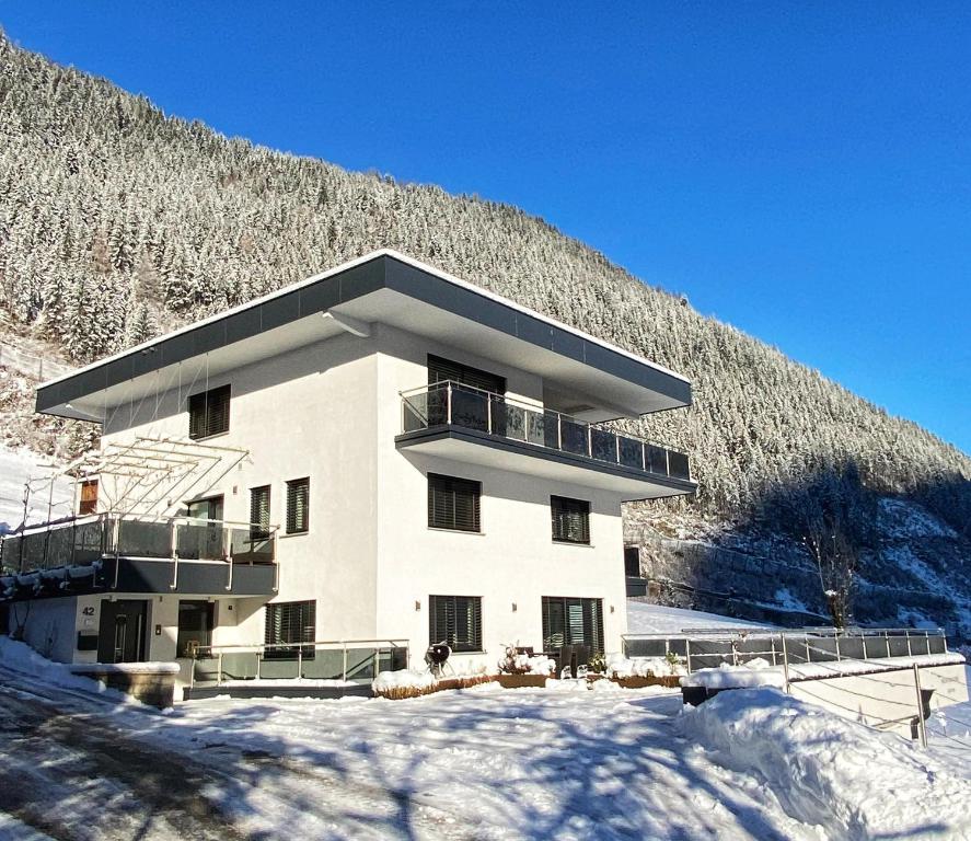 a large building with snow in front of a mountain at MOUNTAIN HOME apartment in Finkenberg
