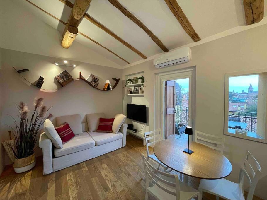 ein Wohnzimmer mit einem Sofa und einem Tisch in der Unterkunft Romantic attic room with panoramic view in Bologna