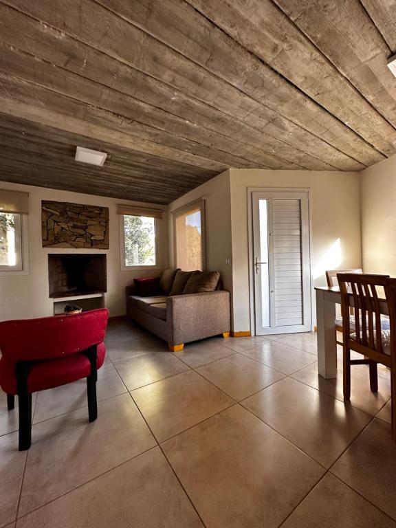 uma sala de estar com um sofá e uma cadeira vermelha em Hermoso departamento a estrenar em San Carlos de Bariloche