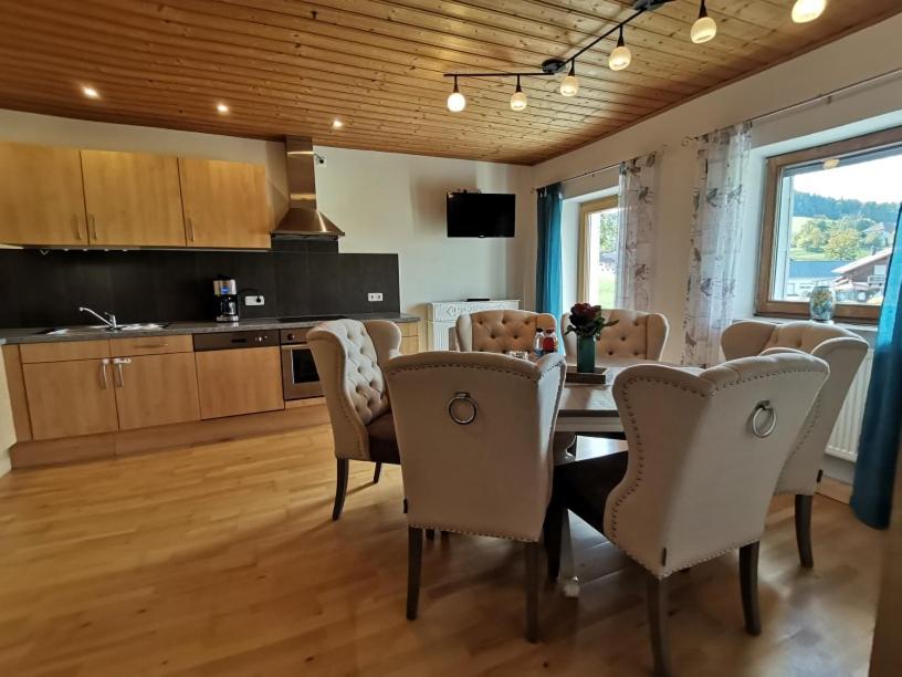 a kitchen and dining room with a table and chairs at Ferienwohnung mit 3 Schlafzimmern Hartl Hof in Breitenberg