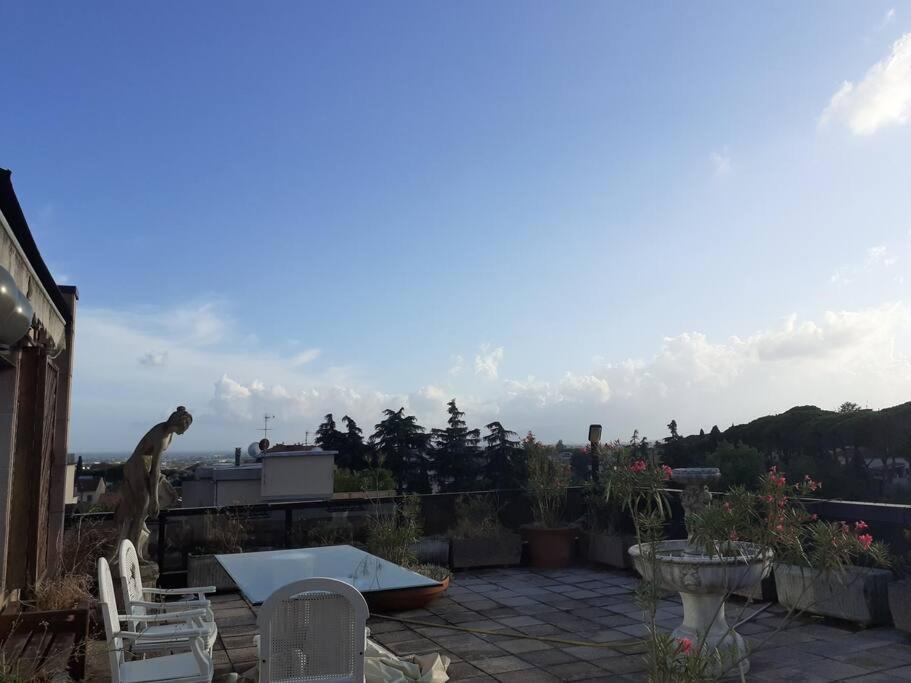 eine Terrasse mit Stühlen und einem Tisch auf dem Dach in der Unterkunft Attico con vista panoramica! in Montecatini Terme
