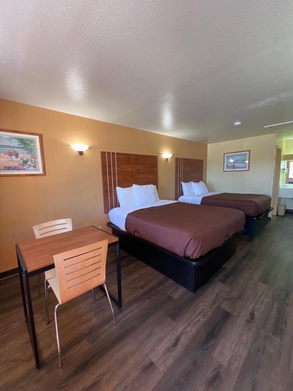 a hotel room with two beds and a table at Executive Inn & Suites Lackland AFB in San Antonio