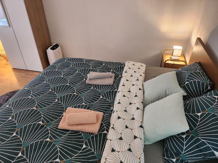 a bed with two pillows on top of it at Duplex confortable proche Paris in La Courneuve