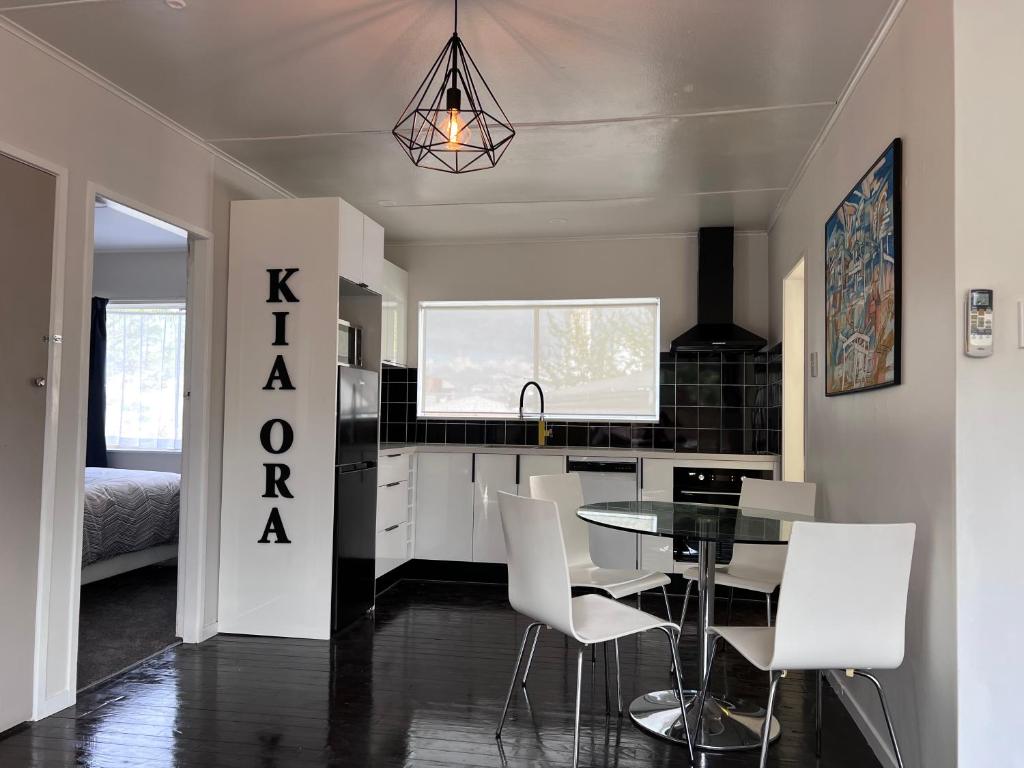 - une cuisine et une salle à manger avec une table et des chaises dans l'établissement Under Walnut Tree, à Rotorua