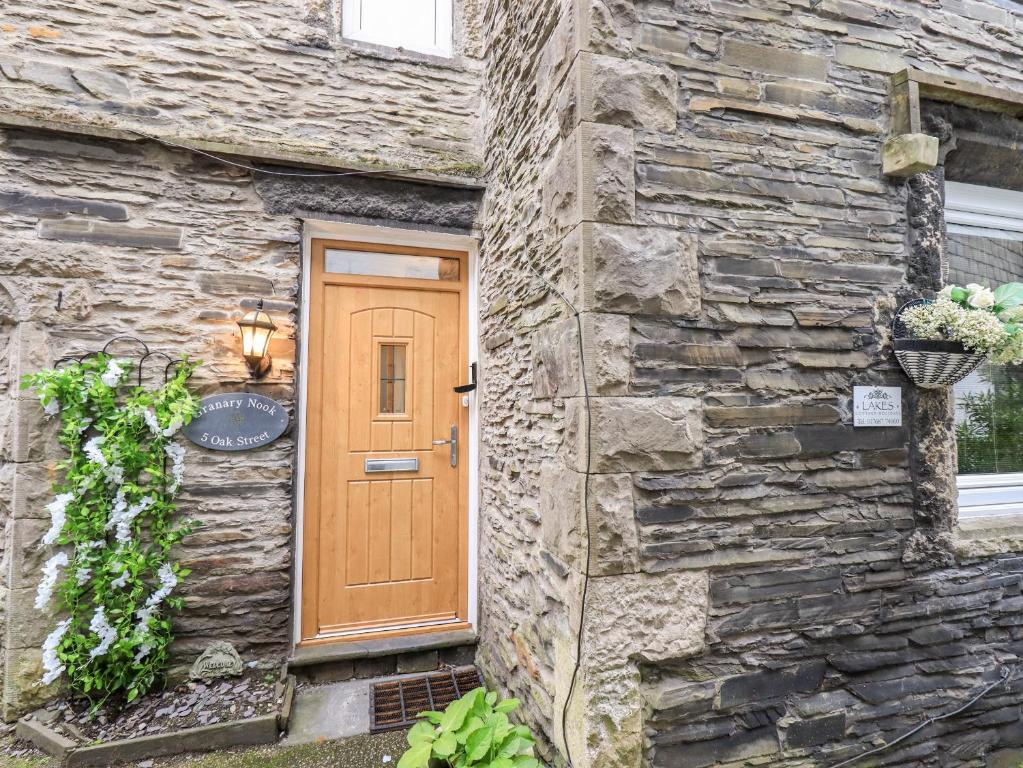 - une porte en bois sur le côté d'un bâtiment en pierre dans l'établissement Granary Nook, à Windermere