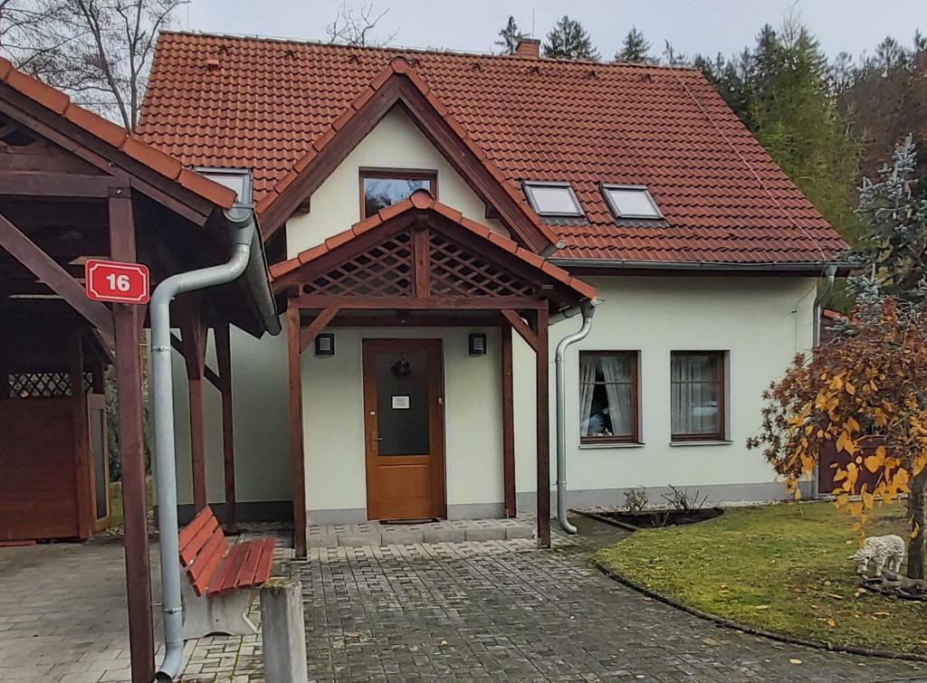 una pequeña casa blanca con techo marrón en Villa Gejzir 16, en Karlovy Vary