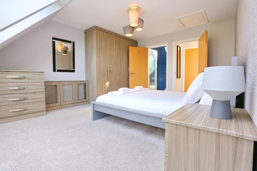 a large bedroom with a bed and a dresser at Luxurious Townhouse In Central Manchester in Manchester