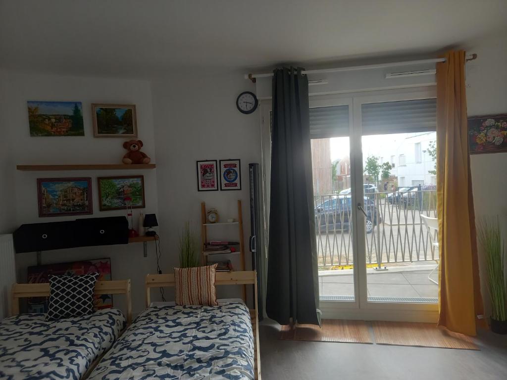 une chambre avec un lit et une porte coulissante en verre dans l'établissement studio à disneyland Paris, à Bussy-Saint-Georges