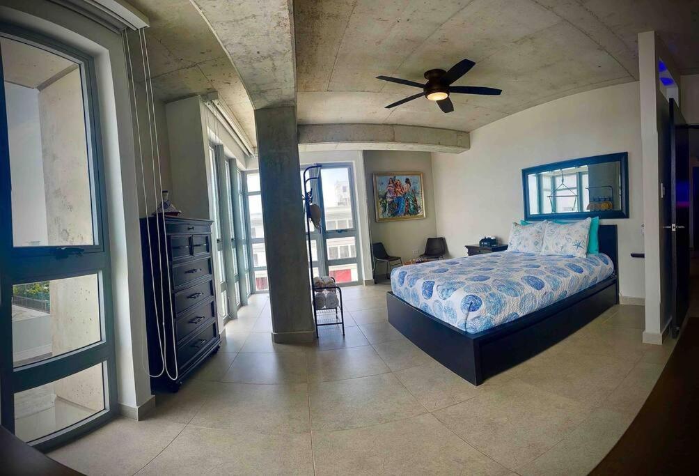 a bedroom with a bed and a ceiling fan at Atlantis Spacious Loft-Sea view in San Juan