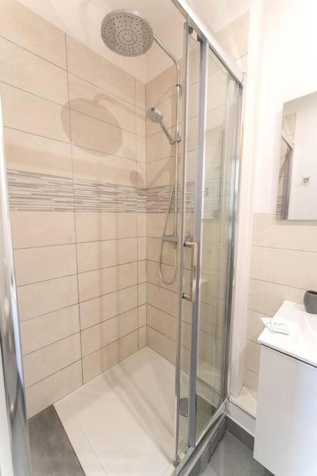 La salle de bains est pourvue d&#39;une douche avec une porte en verre. dans l&#39;établissement NICE 3 CENTRE-VILLE STUDIO EN ETAGE REFAIT A NEUF, à Nice