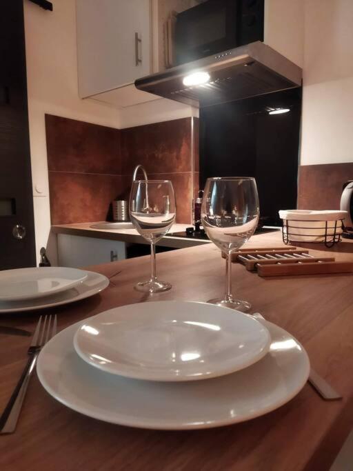 - une table avec deux assiettes et deux verres à vin dans l'établissement NICE 3 CENTRE-VILLE STUDIO EN ETAGE REFAIT A NEUF, à Nice