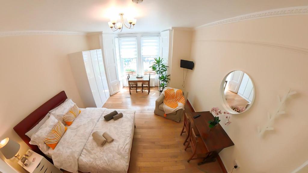 a bedroom with a bed and a mirror and a table at Lovely&Bright Studio Flat Close to Central London in London