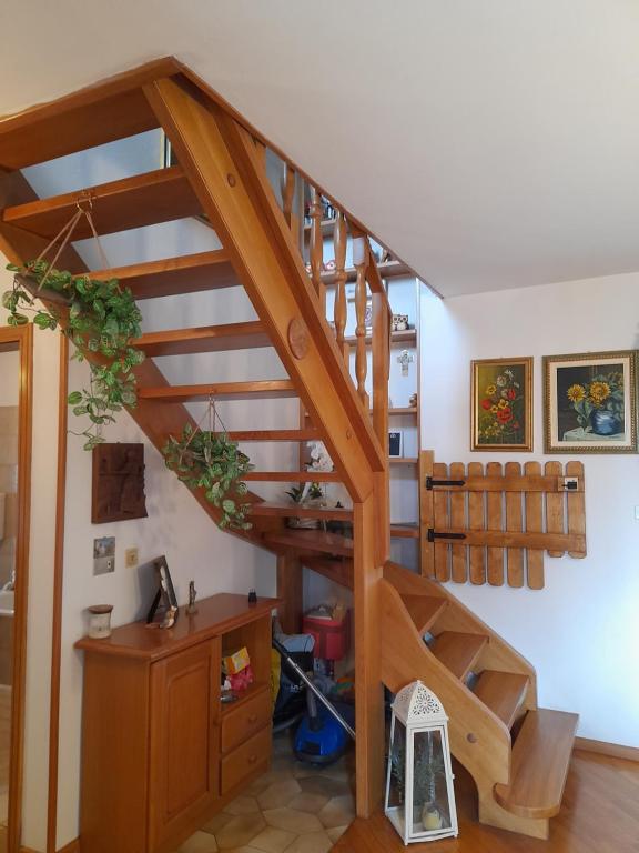 Bedollo的住宿－la casa del zio Bepi，一张桌子,房子里有一个木制螺旋楼梯