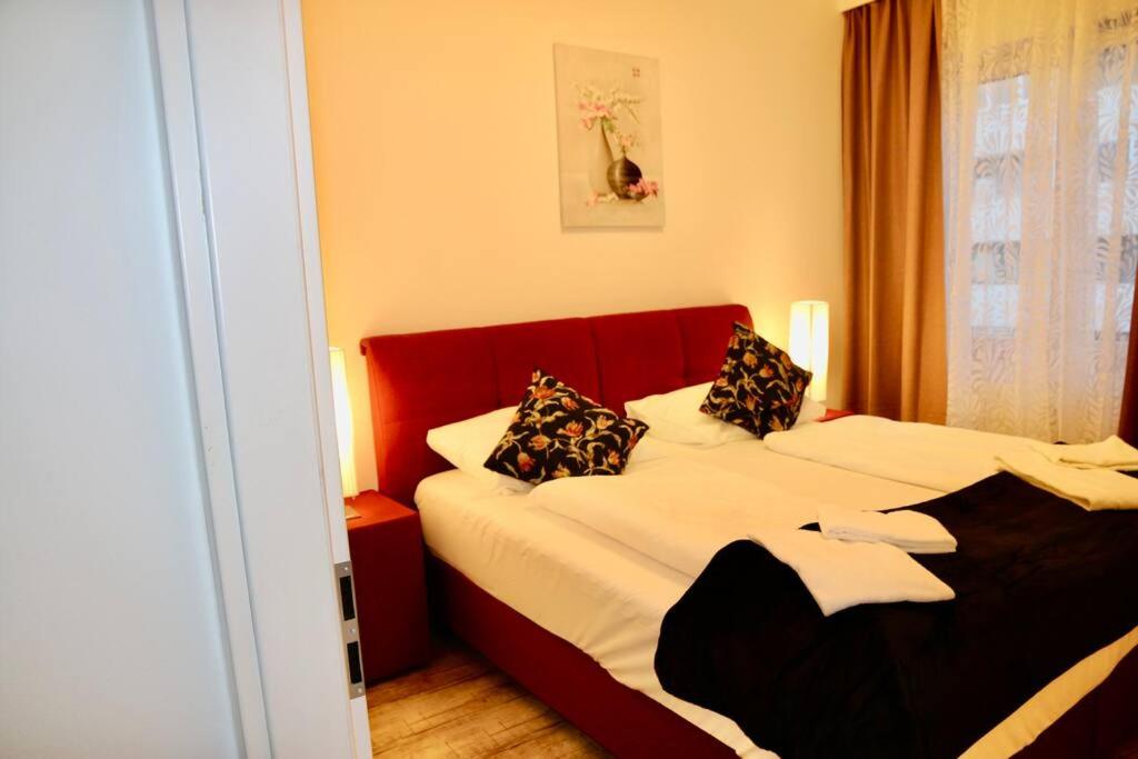 ザルツブルクにあるThe City Appartmentのベッドルーム1室(赤いヘッドボード付きのベッド1台付)