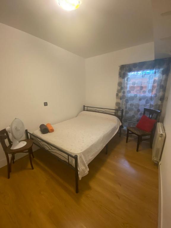 una piccola camera con un letto e due sedie di Chamartin De frente a 4 torres a Madrid
