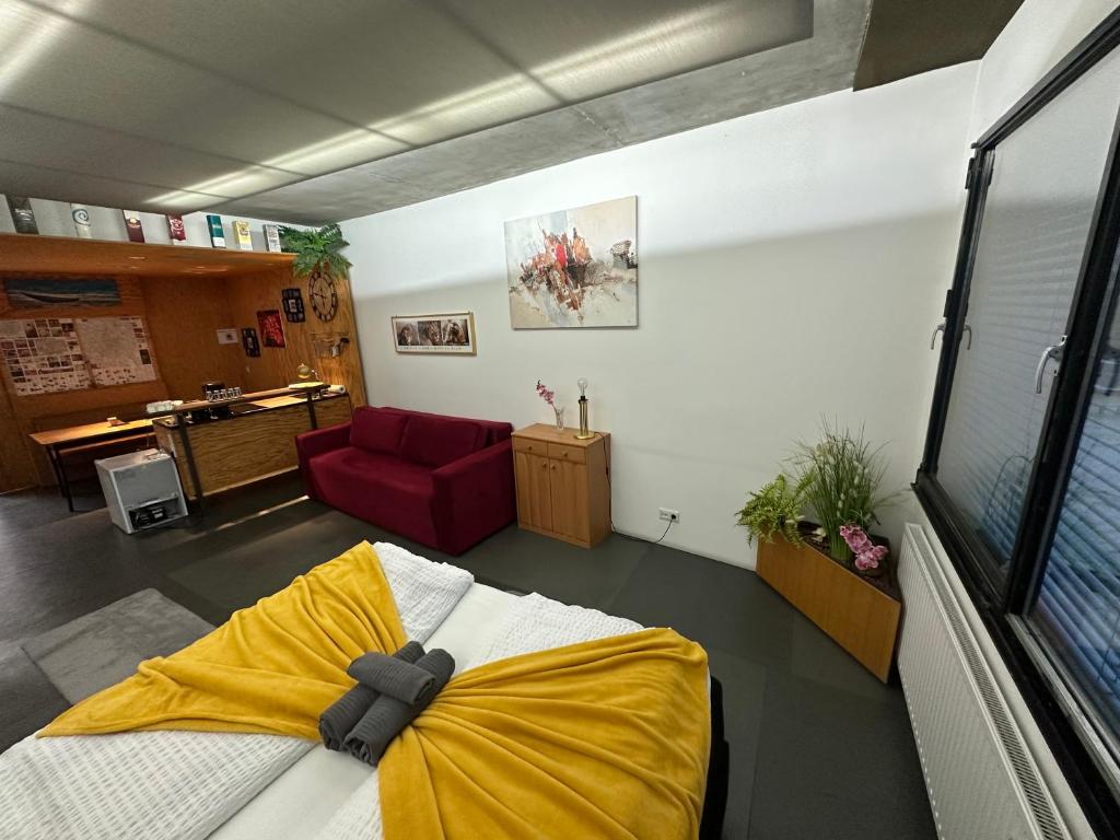 Zimmer mit einem Bett und einem roten Sofa in der Unterkunft Apartment am Schwedenplatz in Wien