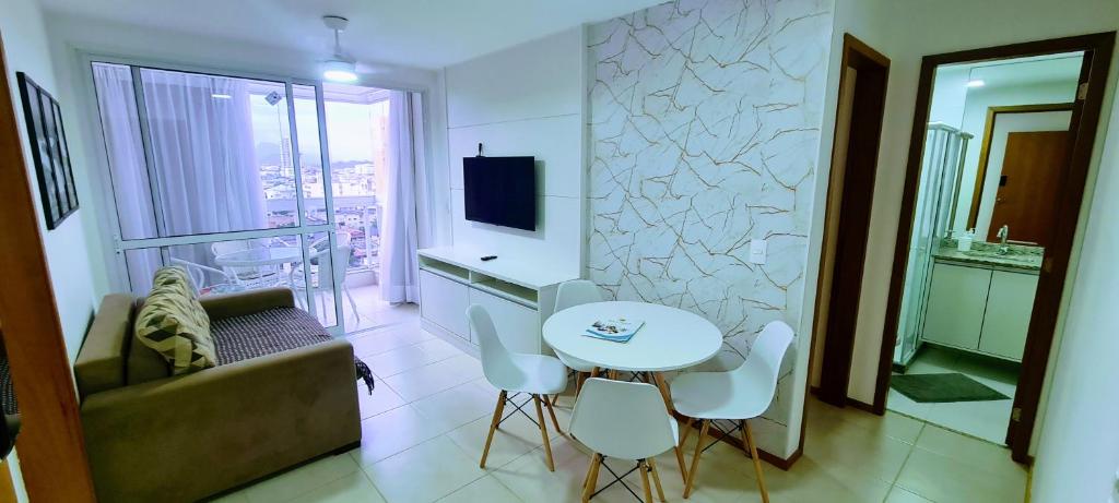 a small living room with a table and a couch at Wave Itapoã 702 Sul - Praia de Itapoã - Beverly Hills, comércio, piscinas panorâmicas, minimercado e lavanderia in Vila Velha