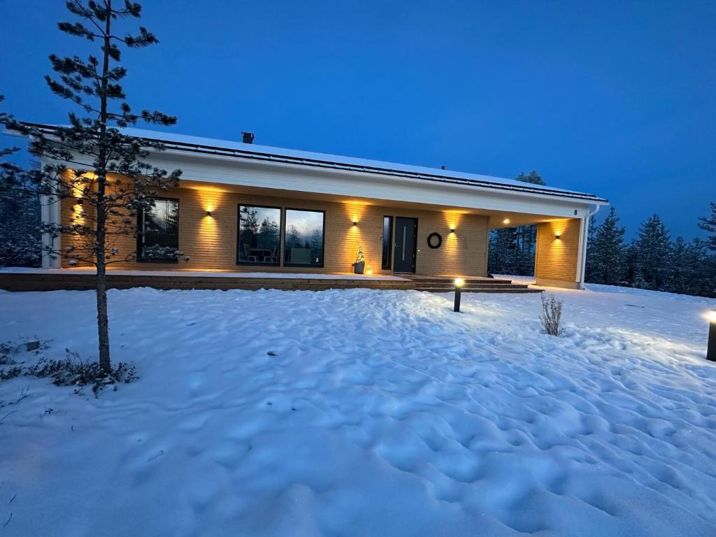 a house in the snow at night at Brand New! Villa Moon in Rovaniemi