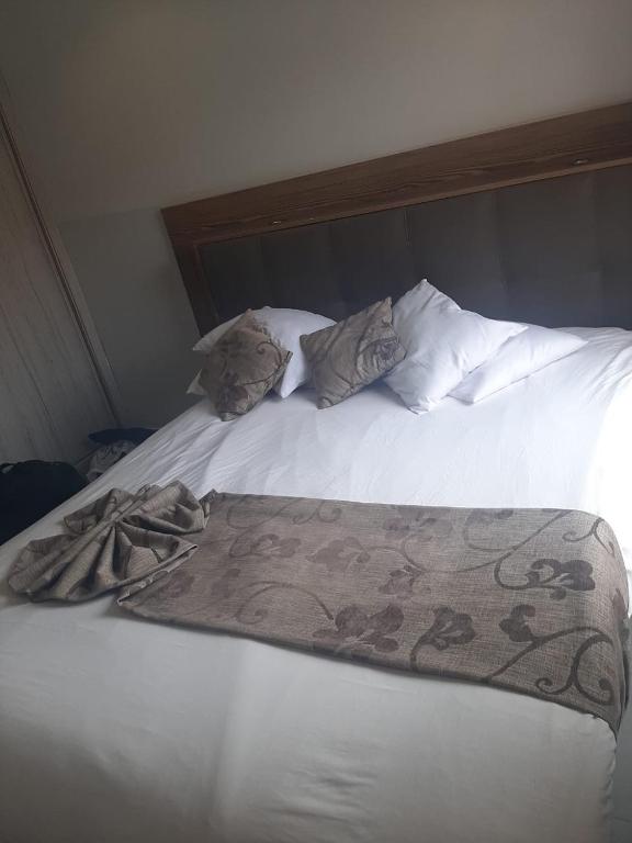 een wit bed met twee kussens en een deken erop bij Appartement Anis in Agadir