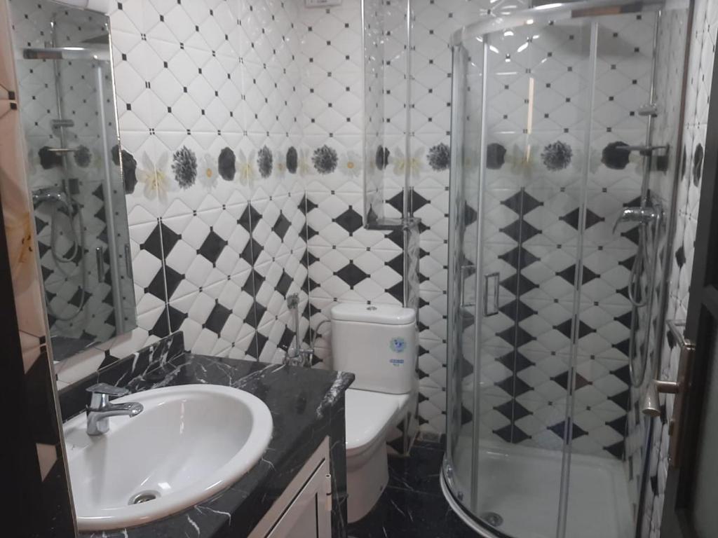 y baño con ducha, aseo y lavamanos. en Appartement Anis, en Agadir