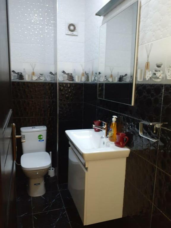 een badkamer met een wit toilet en een wastafel bij Appartement Anis in Agadir