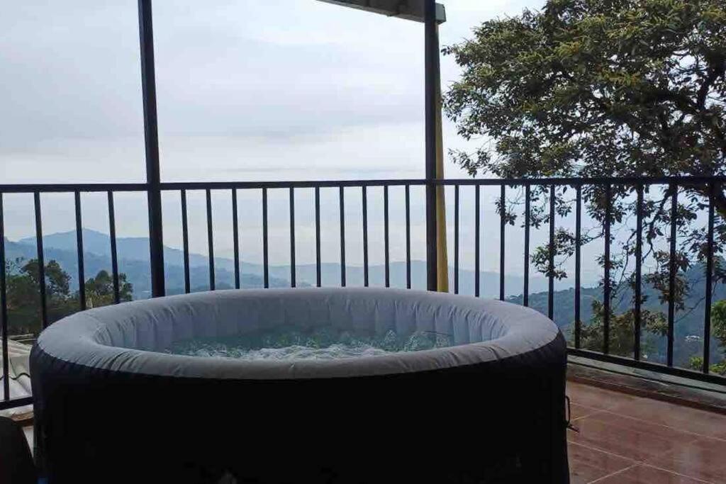 einen großen Whirlpool auf einem Balkon mit Aussicht in der Unterkunft Ecocasa Impresionante panorámica jacuzzi Smart TV in Yumbo