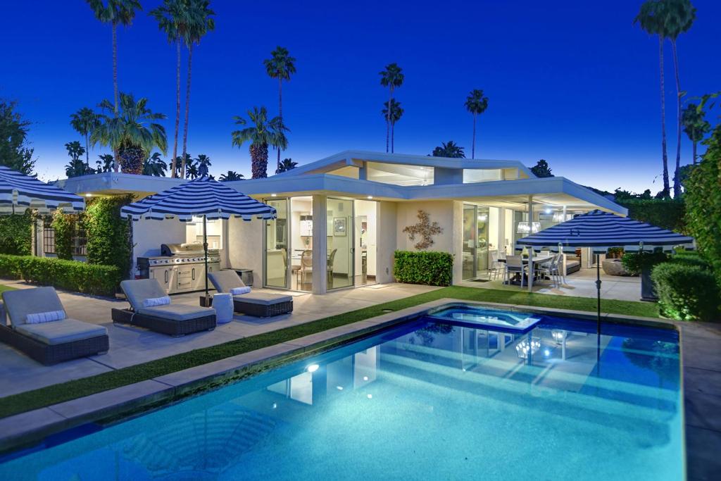 a house with a swimming pool in front of a house at Canyon Palms Estate- Ultra-Luxe, Pool, Spa, Firepit, Outdoor Kitchen & More in Palm Springs