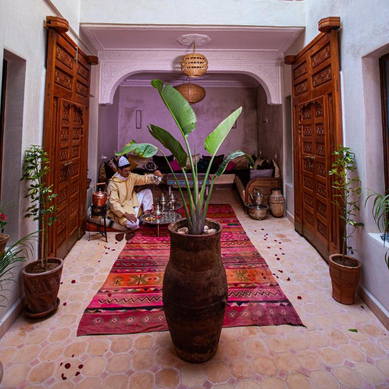 マラケシュにあるRiad Taziriの植物を植えた大花瓶のある部屋