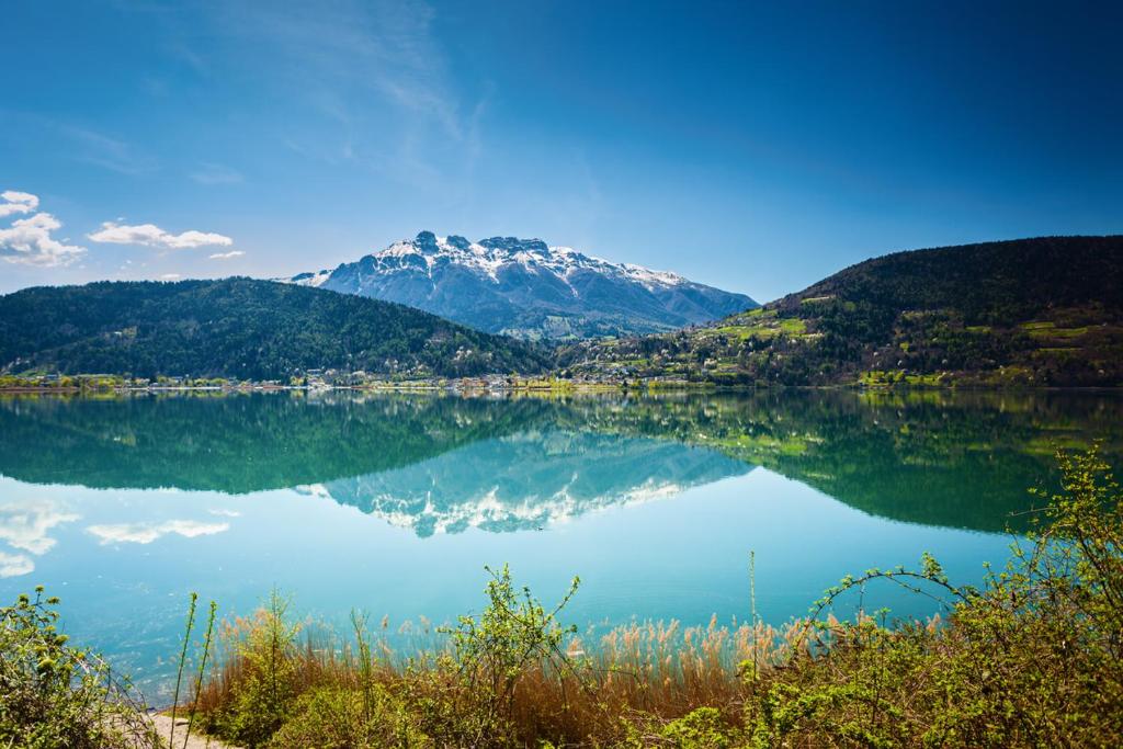 un reflejo de una montaña en un lago en Appartamento lake-side, en Calceranica al Lago