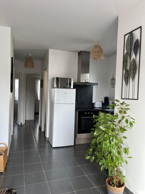 eine Küche mit einem weißen Kühlschrank und Fliesenboden in der Unterkunft Maison Eugenie Arena, Gendarmerie, Rocade in Bouliac