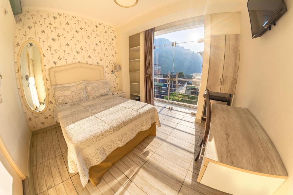 um pequeno quarto com uma cama e uma janela em Hotel Natural Green Lounge em Tingo María