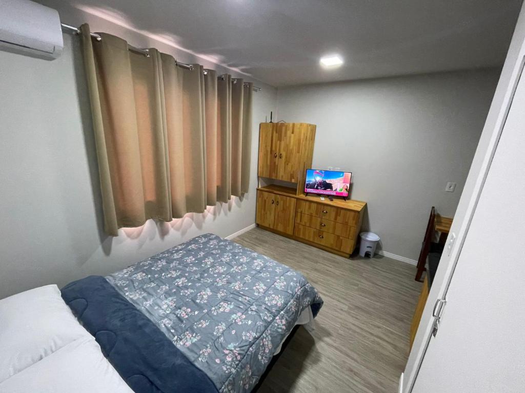 een slaapkamer met een bed en een tv. bij Apto tipo Estudio Cod 206 in Timbó