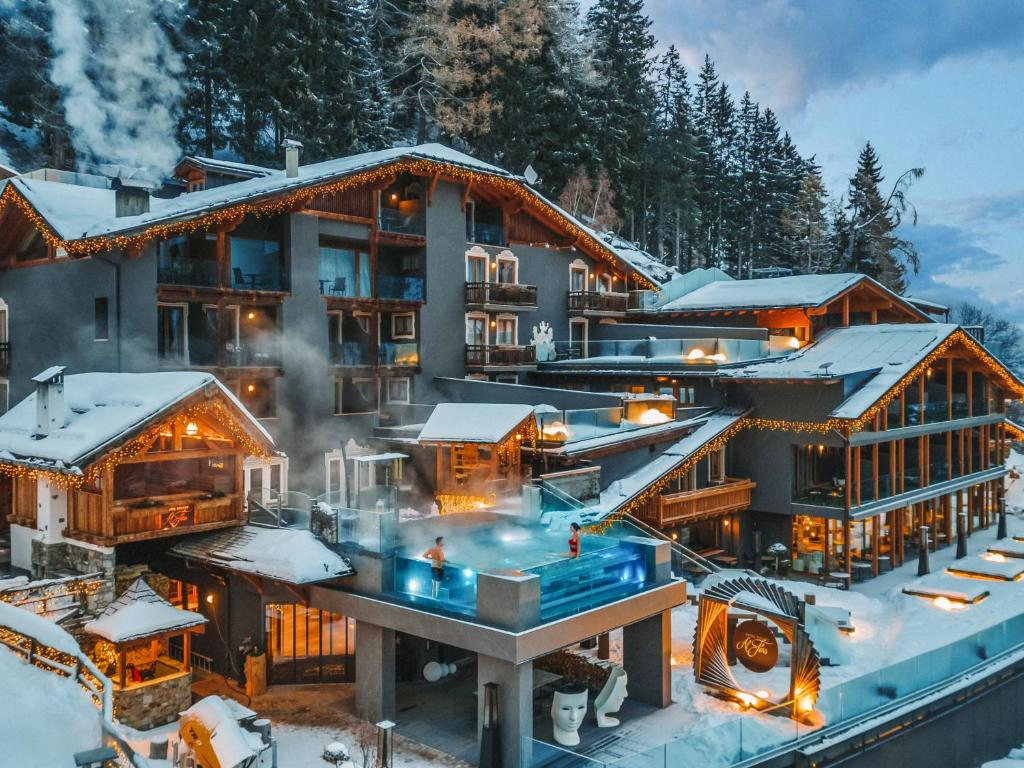 a building with a pool in the snow at Hotel Chalet Al Foss in Vermiglio