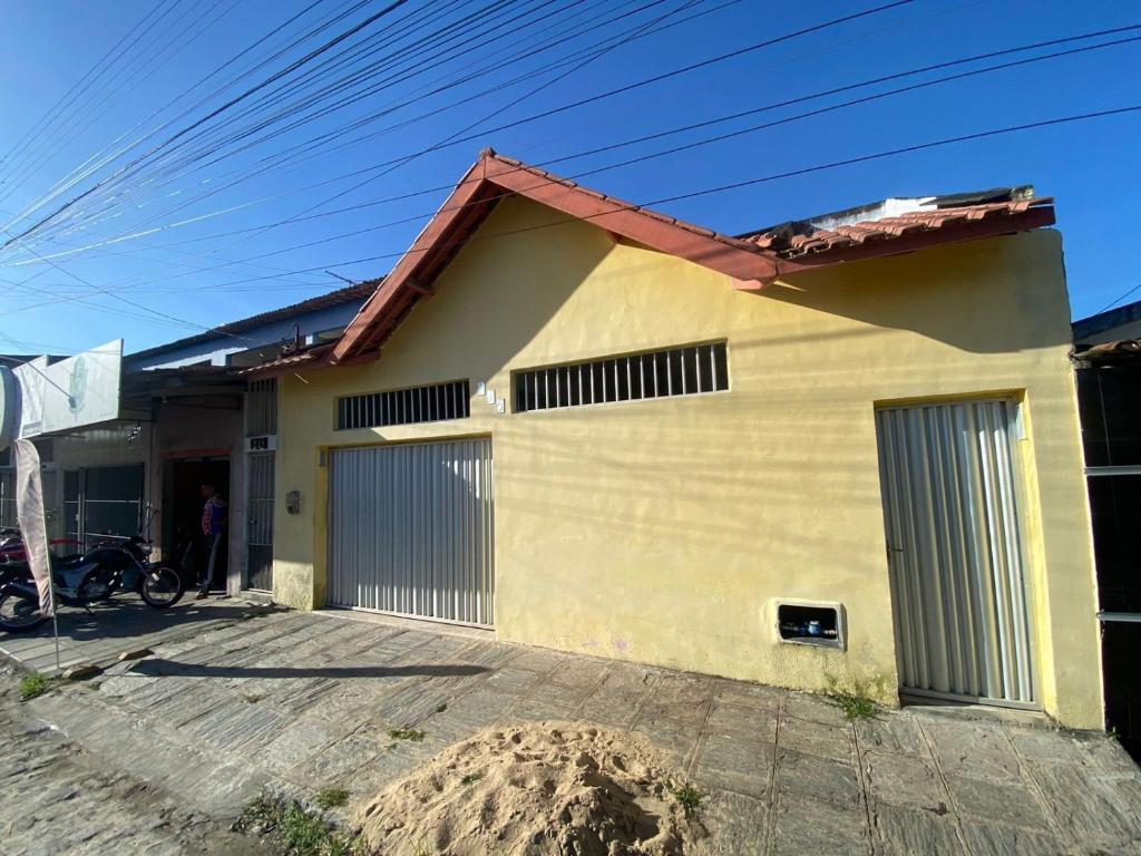 a house with two garage doors in front of it at Temporada CG - Casinha da Vovo in Campina Grande