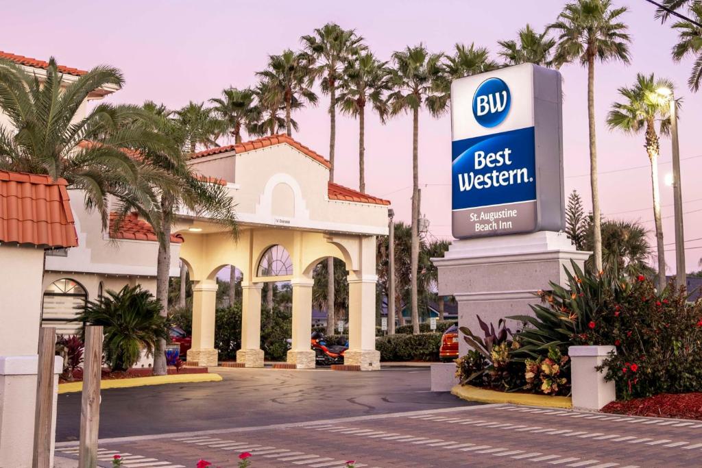 a best western sign in front of a building with palm trees at Best Western Seaside Inn in Saint Augustine Beach