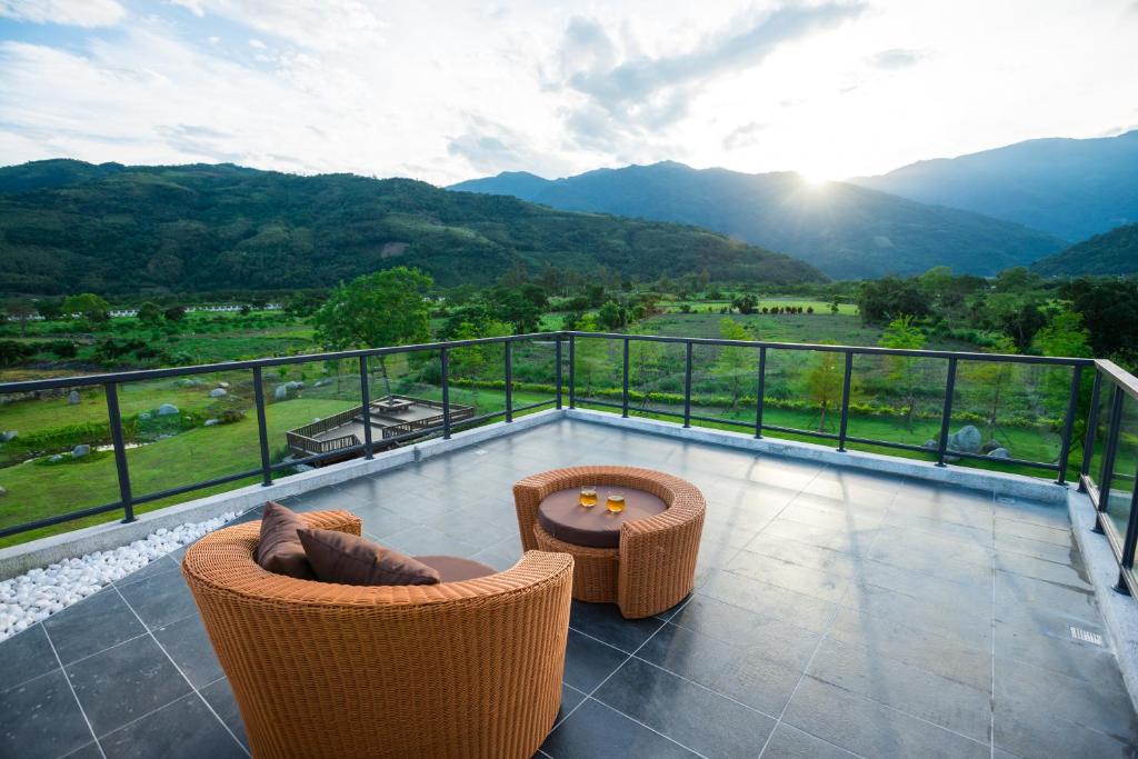 a balcony with two chairs and a table and mountains at The Silence Manor in Ruisui