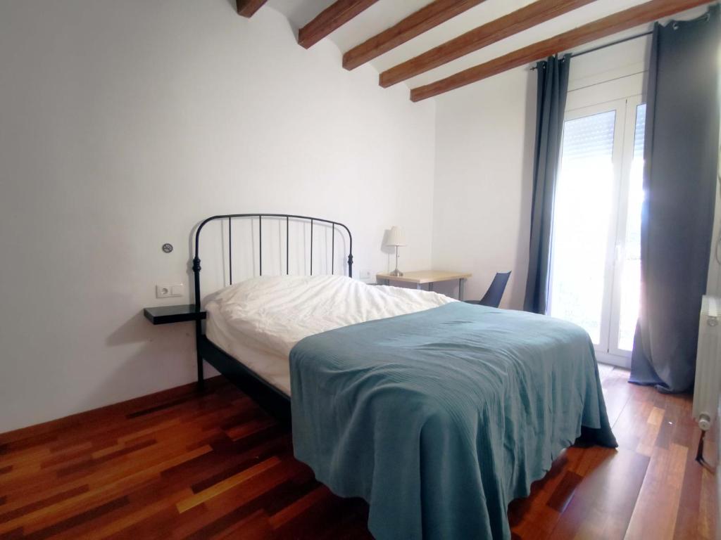 Un dormitorio con una cama en una habitación con suelo de madera. en VL51, en Barcelona