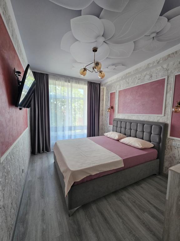 een slaapkamer met een groot bed en een plafond bij Modern Apartment in Chişinău