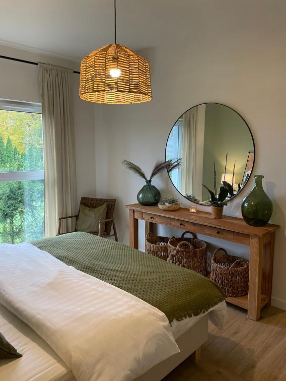a bedroom with a bed and a large mirror at Apartament FOREST - HOME APART in Ostróda