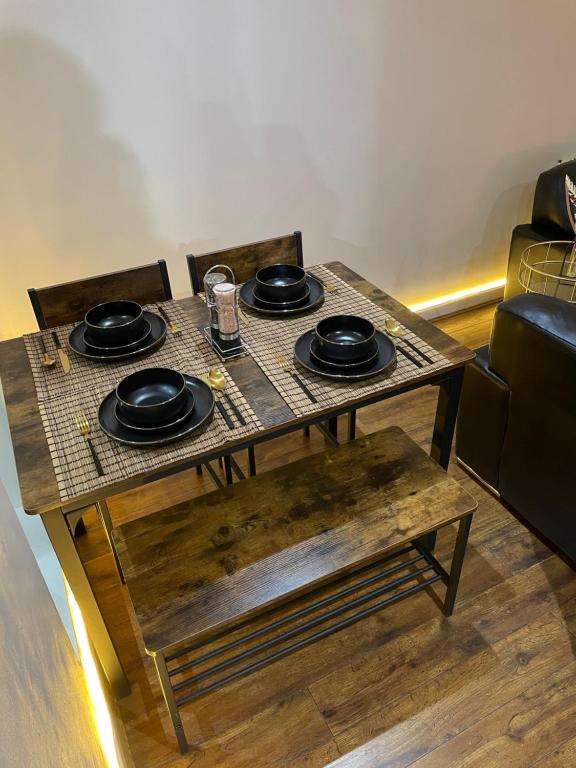 a table with black plates on top of it at Luxury 1 or 2 bedroom Apartment Birmingham City Centre in Birmingham
