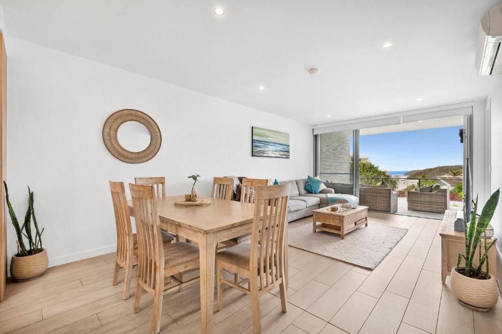 a dining room with a table and chairs and a couch at Unit 406 Drift in Coolum Beach