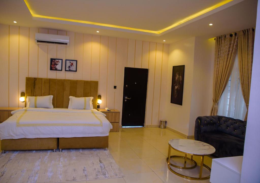 a bedroom with a bed and a couch and a table at Elcastillo Homes in Lagos