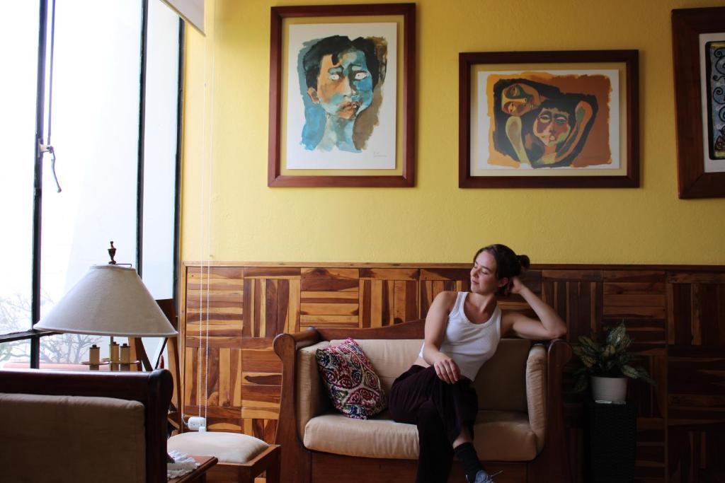 a woman sitting on a couch in a living room at Casa de Tulia in Quito