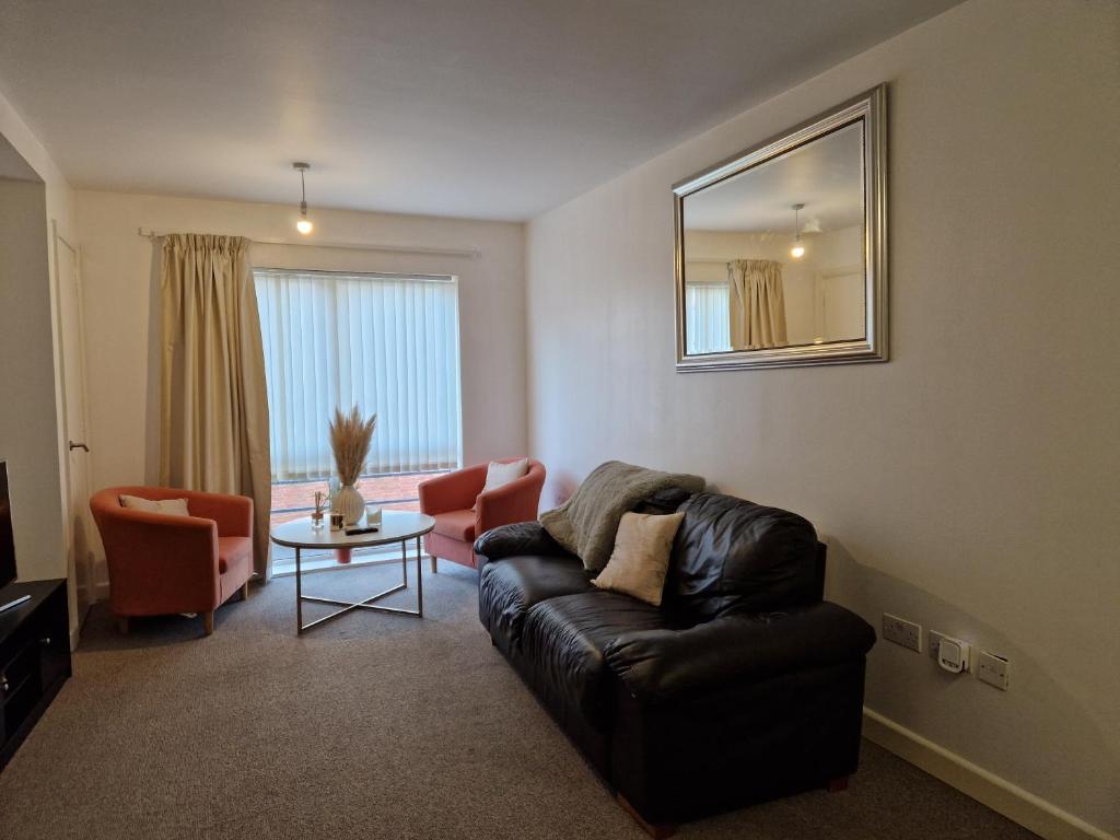 a living room with a leather couch and a table at Remarkable 1-Bed Apartment in Northampton Town cen in Northampton