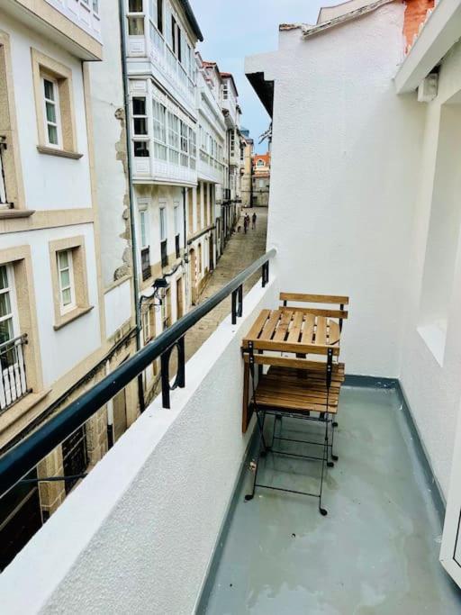 un banco sentado en el balcón de un edificio en El sauce de la calle Sinagoga Precioso apartamento en el centro de La Coruña, en A Coruña