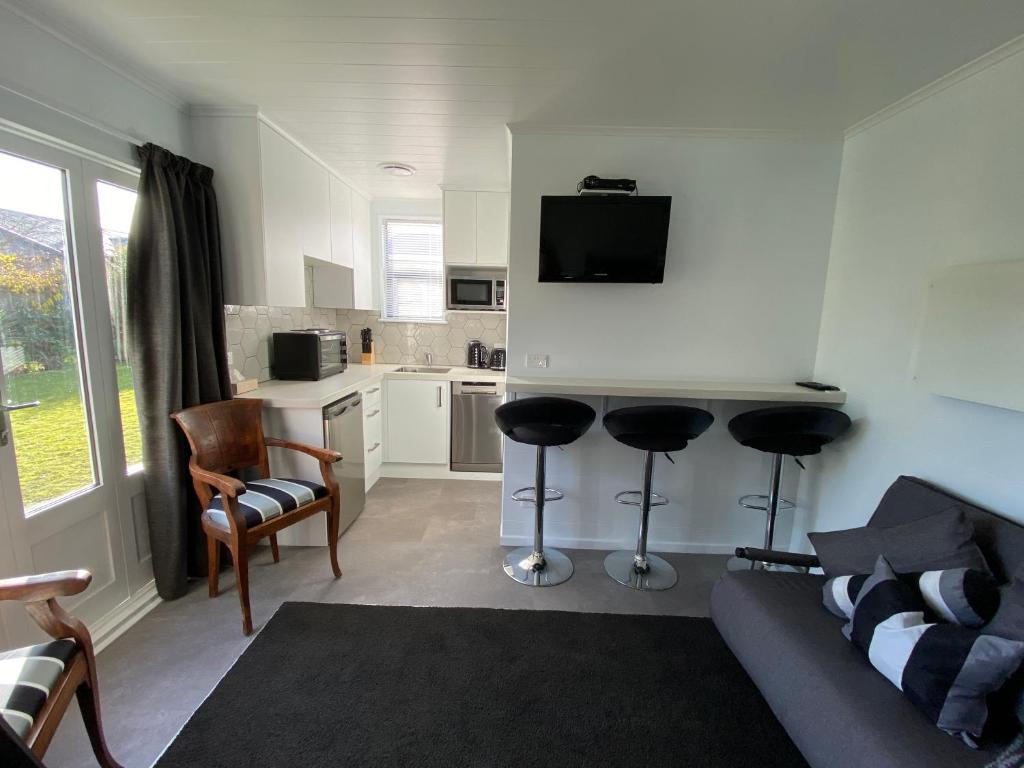 a living room with a couch and chairs and a kitchen at Methven Retreat Tiny House in Methven