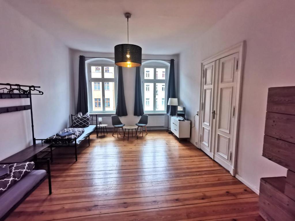 柏林的住宿－Schöne Unterkunft in Prenzlauer-Berg，客厅拥有白色的墙壁和硬木地板。