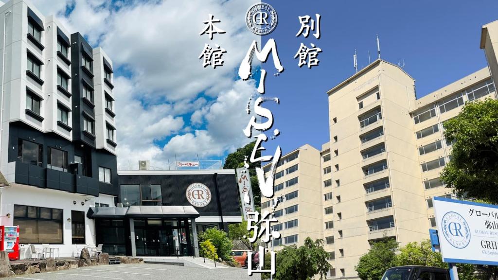 um grupo de edifícios com escritos asiáticos sobre eles em Global Resort Misen - グローバルリゾート弥山 em Hatsukaichi